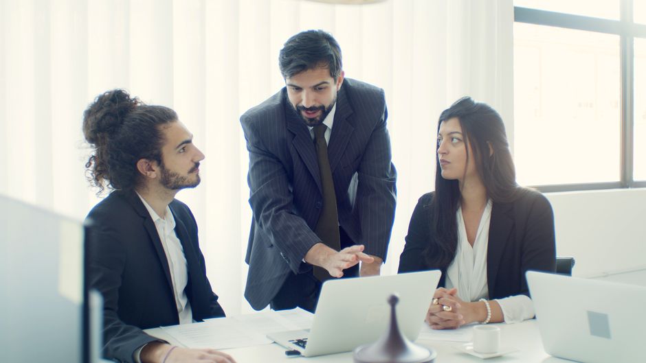 Professional team in office discussing a business project with focused collaboration.